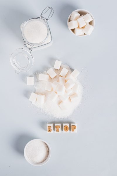 The word stop on pieces of refined sugar as a symbol of refusal from sugar top and vertical view